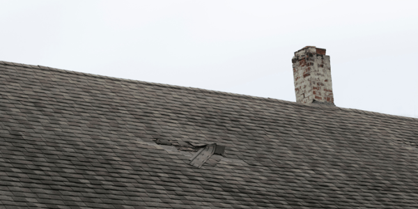Roof that has damaged shingles due to a storm